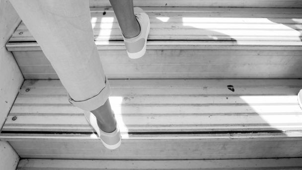Schwarz-Weiß-Bild weiblicher Füße auf Flugzeugtreppen - Foto, Bild