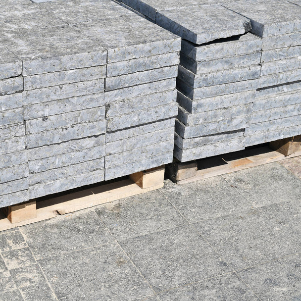 Granieten tegels op pallets op een bouwplaats. - Foto, afbeelding