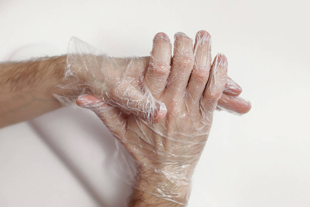 De man doet massage van de handen door middel van een masker-een handschoen voor de handen. De voedzame, herstel crème. Mooie mannelijke handen. - Foto, afbeelding