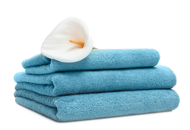 Stack of clean folded towels with flower on white background - Photo, image