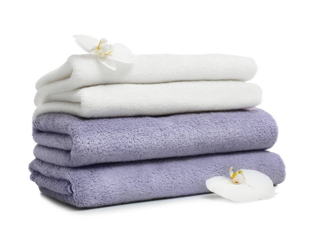 Stack of clean folded towels with flowers on white background - Foto, imagen
