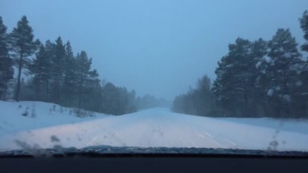 Pov, Close Up: Şiddetli kar fırtınası karanlık sisli kış kötü görünürlük ile tehlikeli karlı kaygan kırsal yolda hız araba. Finlandiya'da kar yağışı sırasında buzlu karayoluna yoğun kar yağıyor - Video, Çekim