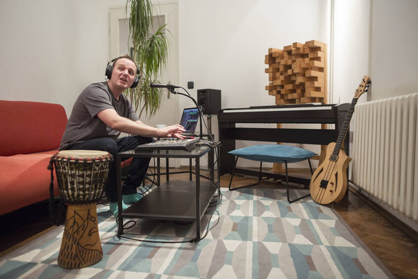 Музикант співає та грає на клавіатурі Midi у студії домашньої музики
. - Фото, зображення