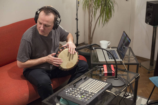 Музикант грає джембе барабанний інструмент в домашній музичній студії
. - Фото, зображення