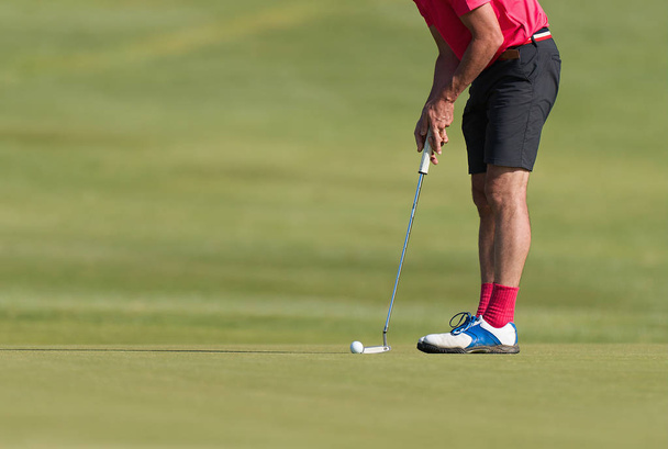 Jugar al golf preparándose para disparar, hombre poniéndose verde
 - Foto, imagen