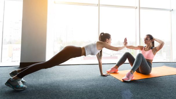 Entrenando juntos. Chicas haciendo ejercicios abdominales y tablón
 - Foto, imagen