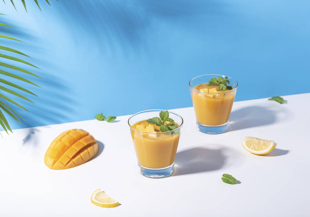 Fresh mango smoothie and ripe mango slice on color background.  - Photo, Image