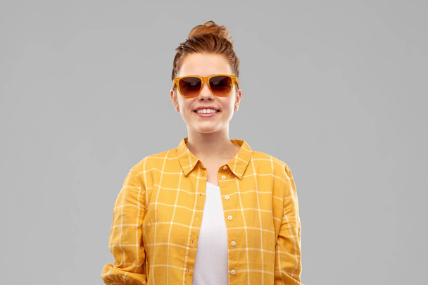 улыбающаяся рыжая девочка-подросток в солнечных очках
 - Фото, изображение