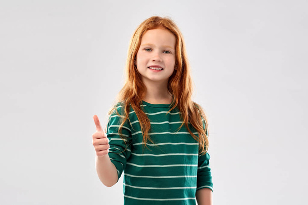 smiling red haired girl showing thumbs up - Foto, immagini