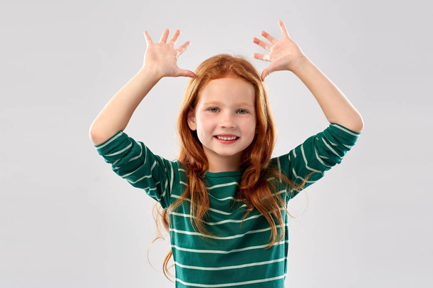 red haired girl having fun and making big ears - Фото, изображение