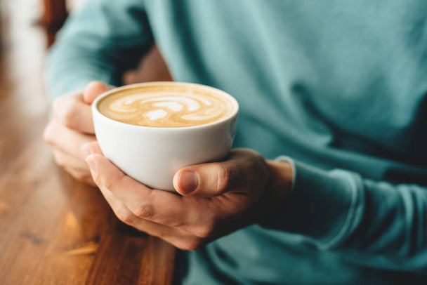 The cup of cappuccino in men's hands - 写真・画像