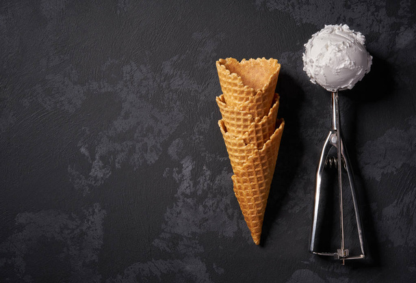 Conos de gofre para helado y una cuchara grande esperando para llenar
, - Foto, Imagen