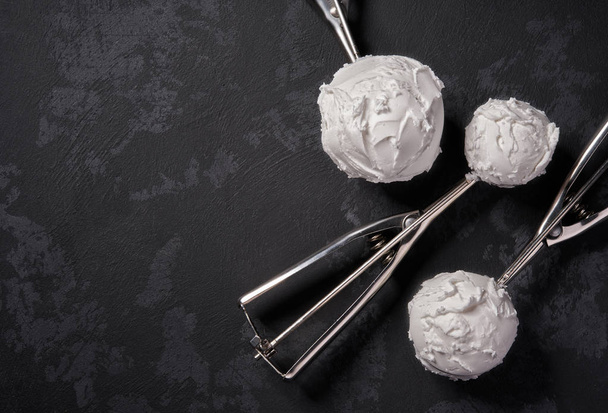 White ice cream on black background, top view. Three scoops of i - Foto, imagen
