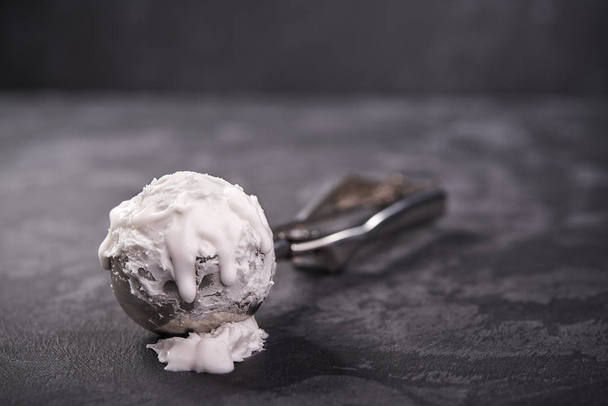 colher de sorvete cheio de sorvete de baunilha no fundo escuro
 - Foto, Imagem