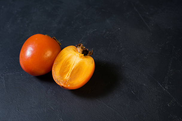 Ripe persimmon on black background with space for text. - Photo, Image