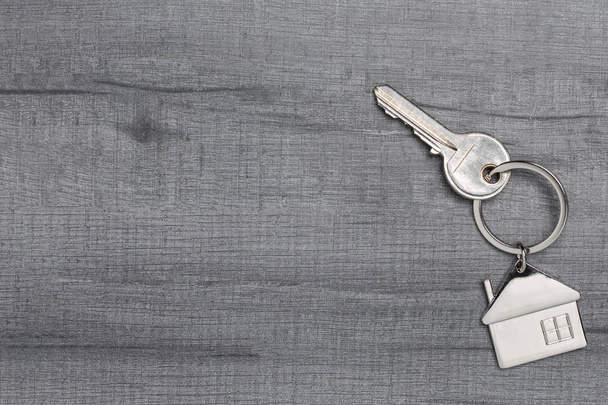 Schlüsselanhänger und Schlüssel auf Holztisch mit Kopierraum - Foto, Bild