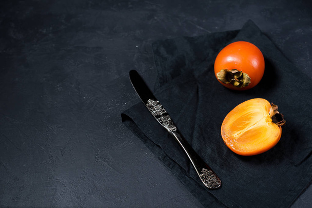 Persimmon on black fabric with space for text. - Photo, Image