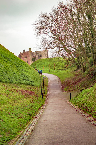 Camino que conduce al castillo de dover y hierba verde en los lados de la misma
 - Foto, Imagen