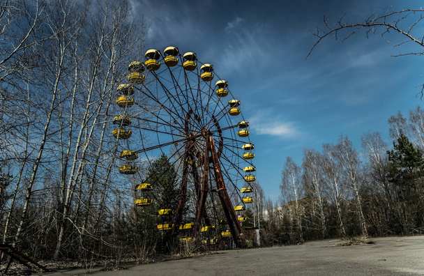 Old ferris wheel in the ghost town of Pripyat. Consequences of the accident at the Chernobil nuclear power plant - Foto, afbeelding