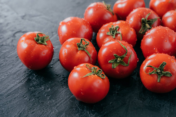 Horizontale schot van rode verse tomaten geoogst voor het maken van groente salade. Gezond eten en vitaminen concept. Sappige organische tomaten - Foto, afbeelding