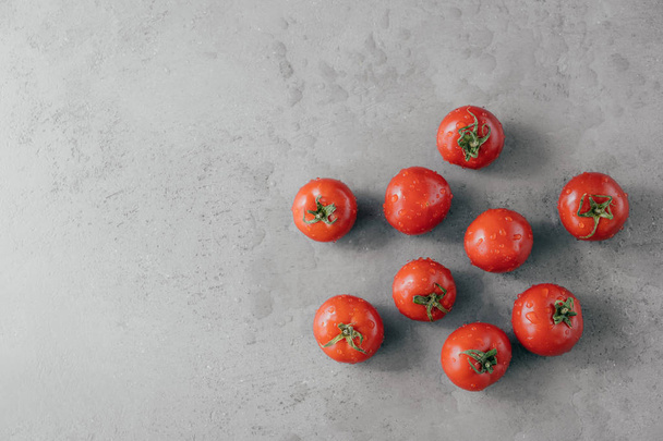 Φρέσκες κόκκινες ντομάτες με σταγόνες νερού απομονωμένες σε γκρι φόντο με χώρο αντιγραφής. Φυσικά βιολογικά τρόφιμα που περιέχουν βιταμίνες - Φωτογραφία, εικόνα