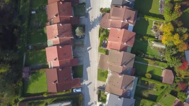 AERIAL TOP DOWN Flying over red rooftops in idyllic suburban town on sunny autumn day. Row houses with green garden lawns in peaceful suburbia. Empty street leading past suburban homes. Quiet suburbia - Footage, Video