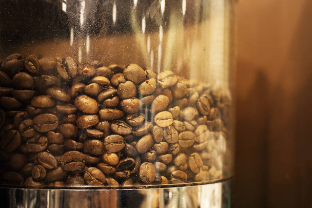 Κόκκοι καφέ σε γυάλινο δοχείο της συσκευής καφέ σε τόνους σέπια - Φωτογραφία, εικόνα