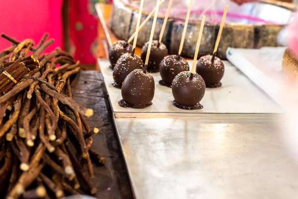 Жареные яблоки, смоченные в шоколаде на ярмарке
. - Фото, изображение