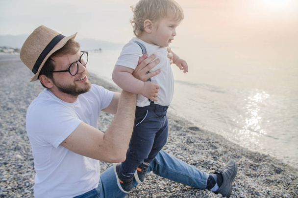father with a little boy son on the beach - Fotó, kép