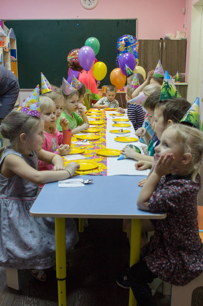 2019.01.22, Moscow, Russia. Children sitting by the festive table. Happy birthday of a little boy in the garden. - Φωτογραφία, εικόνα