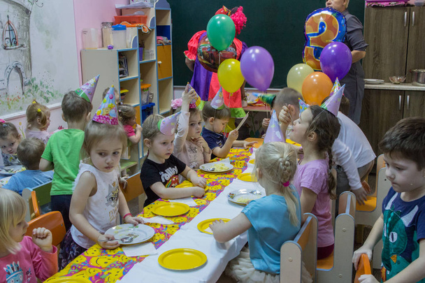 2019.01.22, Moscow, Russia. Children sitting by the festive table. Happy birthday of a little boy in the garden. - Foto, afbeelding
