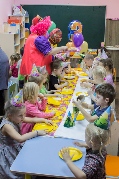 2019.01.22, Moscow, Russia. Children sitting by the festive table. Happy birthday of a little boy in the garden. - Φωτογραφία, εικόνα