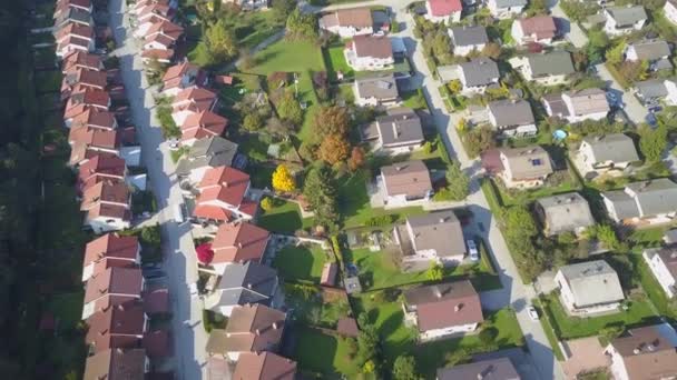 行の家と安全な通りと牧歌的な郊外の町の屋根の上を飛んで空中飛行。晴れた秋の日に美しい郊外。平和な近所に完璧な緑の庭の芝生を持つ行の家 - 映像、動画