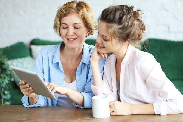 lifestyle, tehnology and people concept: mother and adult daughter using tablet computer at home - Φωτογραφία, εικόνα