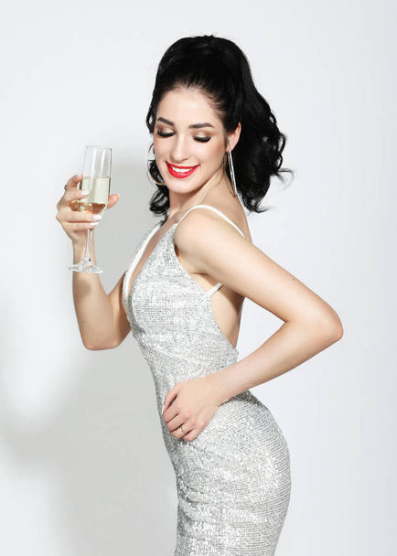 lifestyle and people concept: beautiful girl in a cocktail dress with evening make-up holding a glass of champagne - Foto, afbeelding