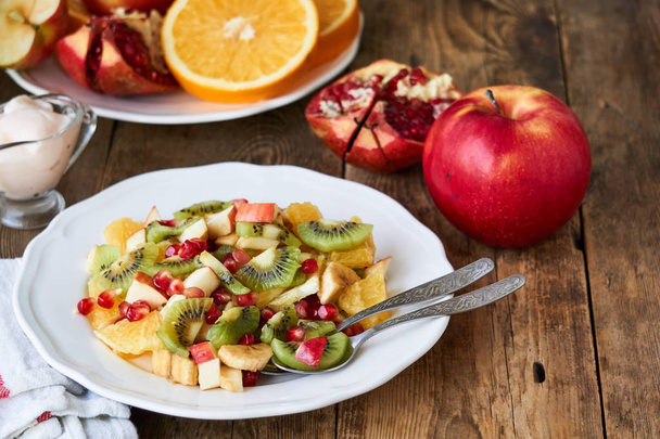 Salad with various fresh fruits on a white plate                                - Foto, immagini