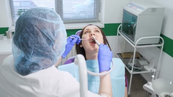 Молода дівчина на профілактичному огляді в стоматологічному кріслі у стоматолога
. - Кадри, відео