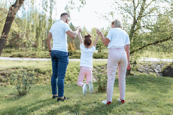 Happy family outdoors. Girl, mother, dad - Fotoğraf, Görsel
