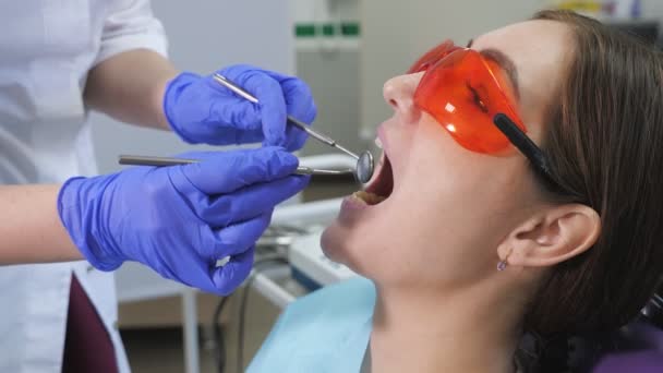 Mujer joven en examen preventivo en silla dental en el dentista. Concepto de cuidado dental
. - Imágenes, Vídeo