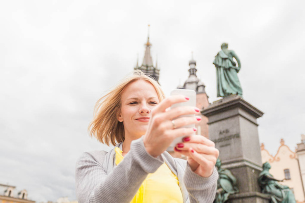 Young beautiful woman on the background of the St. Marys Church in Krakow - Photo, Image
