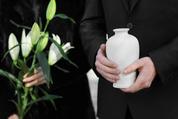 Пара с урной в морге и цветами на похоронах
 - Фото, изображение