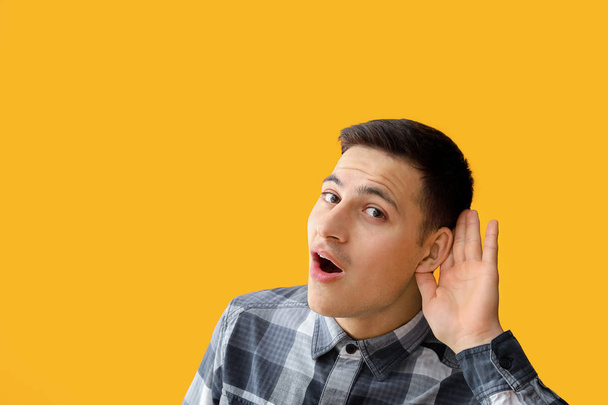 Young man with hearing problem on color background - Foto, afbeelding