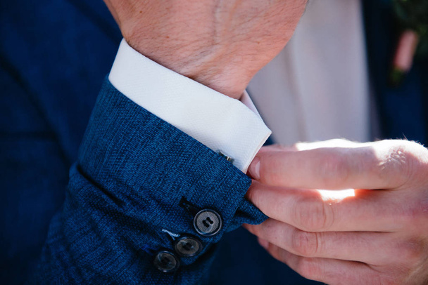 Man in suit with hand adjusts sleeve of shirt close-up - Фото, зображення