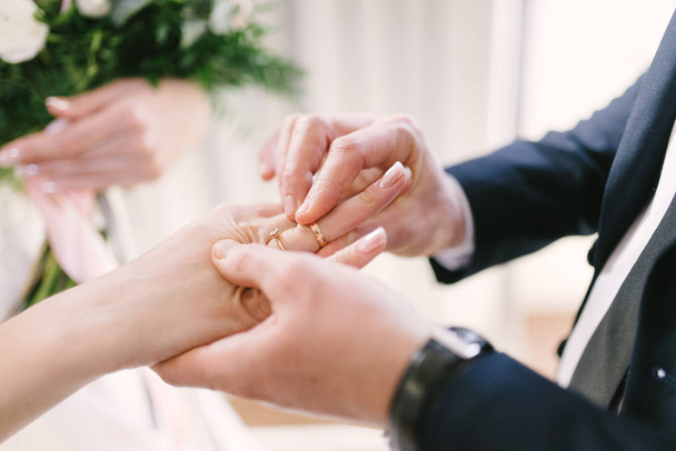 The bridegroom puts the wedding ring on the bride close up. The bride puts the bridegroom on the wedding ring. - Foto, immagini