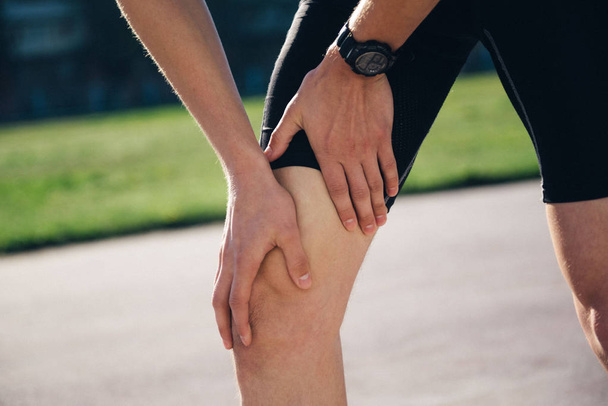 pain in the leg while running in the stadium. Trauma of the leg while running - Foto, Bild