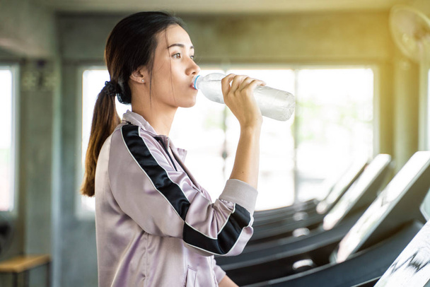 Fitness asian running women drinkink water after run on treadmil - Photo, image
