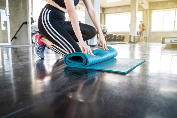 Молоді спортивні йога жінки котиться йога килимок
 - Фото, зображення