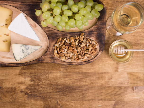 Draufsicht auf Weißwein mit Honig auf Holztisch - Foto, Bild