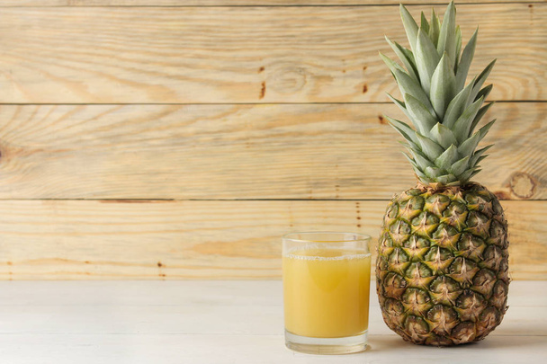 Ripe pineapple fruit and pineapple juice on a natural wooden background. summer. space for text - Photo, Image