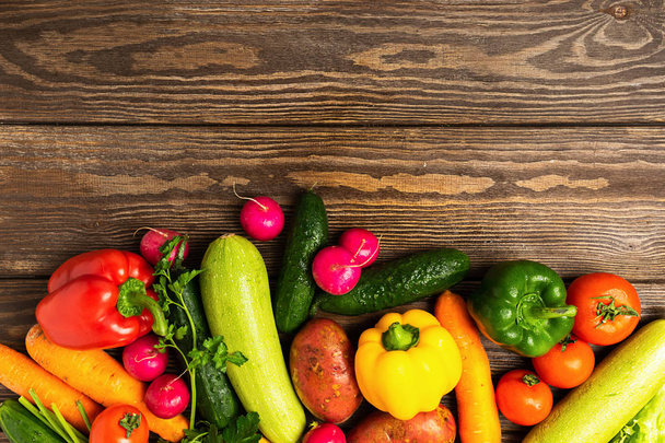 Verduras frescas manojo de verduras sobre fondo de madera. El vegetarianismo es un estilo de vida saludable. Disposición plana. Vista desde arriba
 - Foto, Imagen
